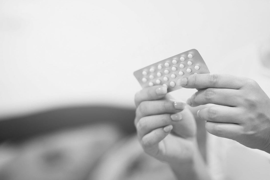 Woman holding oral contraceptive packet